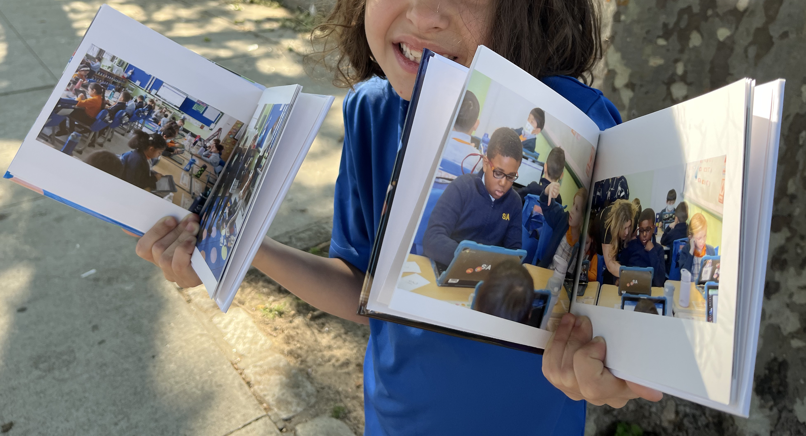 child holds two picture books open to show what's inside