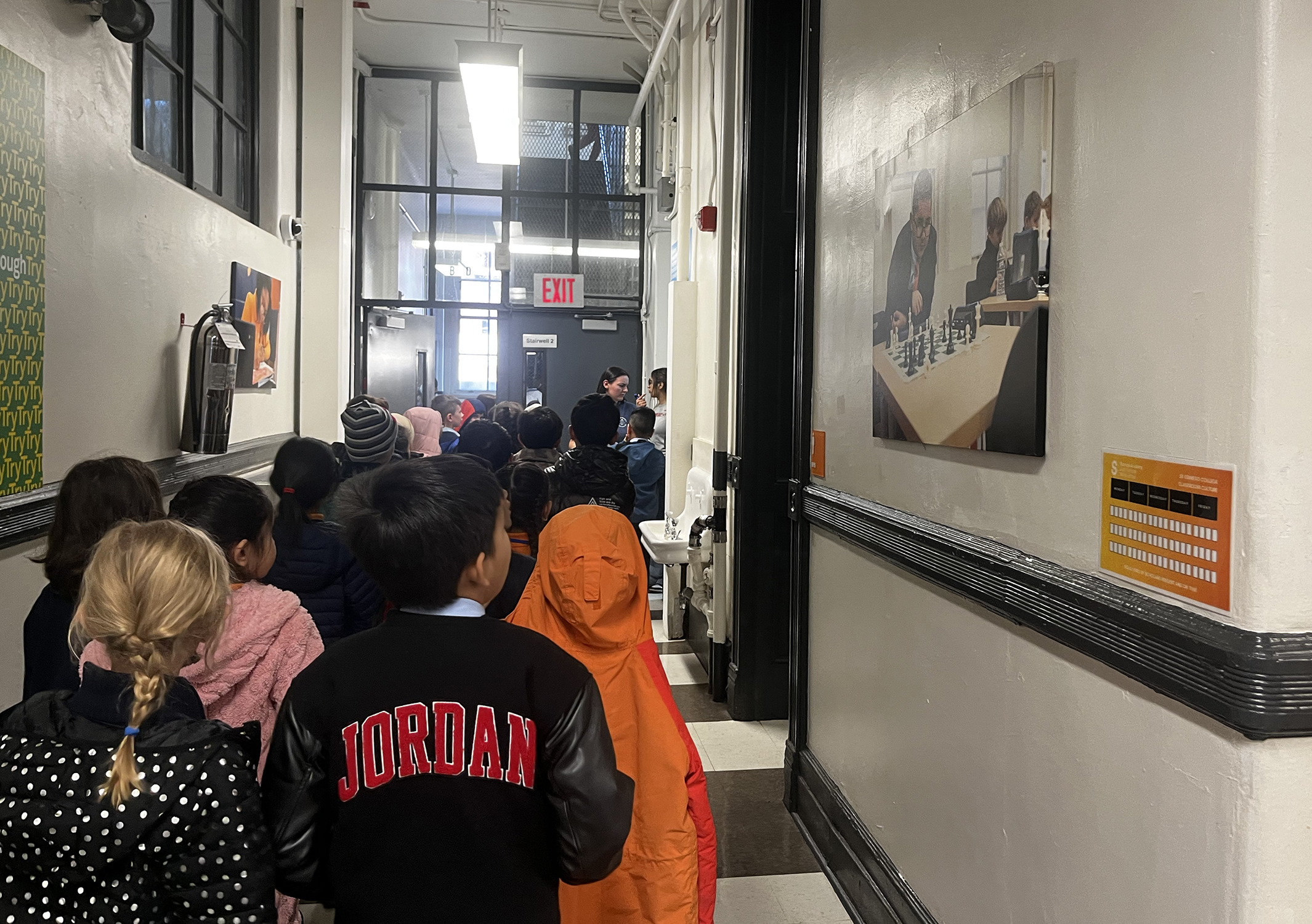 scholars on tour walk past canvas prints of current middle schoolers