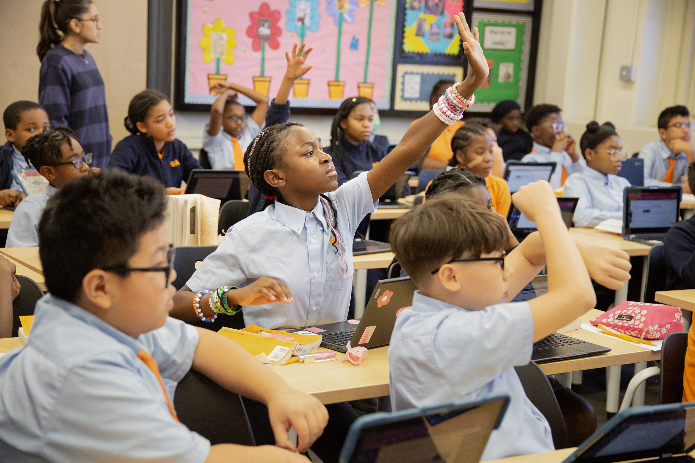 scholar with load of bracelets strains to be noticed raising her hand